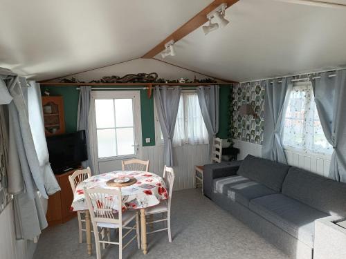 a living room with a table and a couch at Mobil home Cristal in Biville-sur-Mer