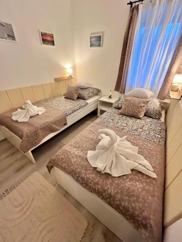 a bedroom with two beds and a window at Majoros Garden Apartman in Siófok