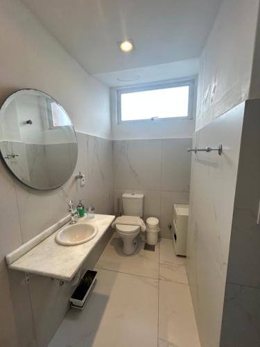 a bathroom with a sink and a toilet and a mirror at 13 andar, Studio, Centro, vista incrível Guaíba in Porto Alegre