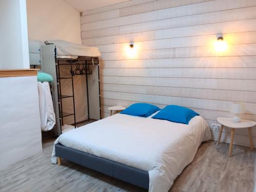 a bedroom with a bed and a wooden wall at Maison ardéchoise atypique in Chomérac