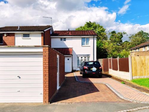 a car parked in the driveway of a house at Spacious White House with parking, garden, Wi-Fi in Telford
