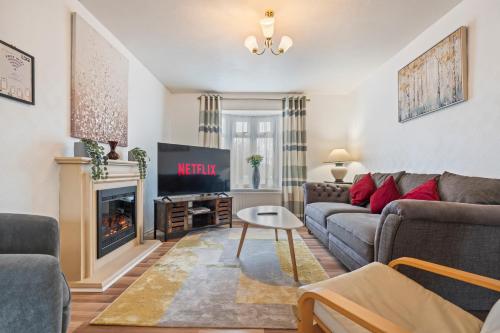 a living room with a couch and a fireplace at Spacious White House with parking, garden, Wi-Fi in Telford