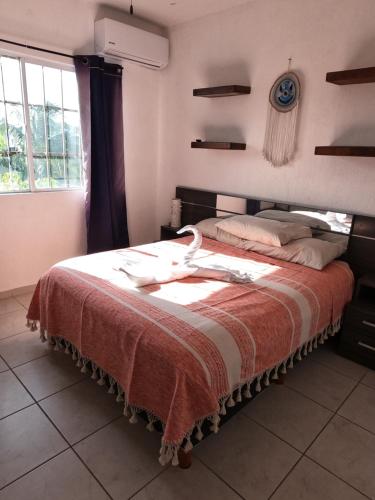 a bedroom with a bed with a bird on it at Casa Atardecer - Privada Los Olivos in Playa del Carmen