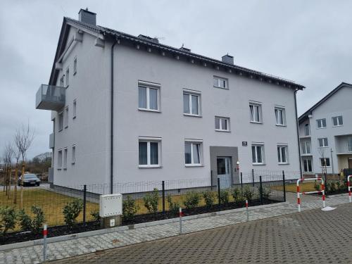a large white building with a fence around it at Apartament Marzeń 13 parter in Kostrzyn nad Odrą