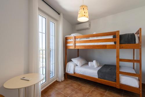 a bedroom with two bunk beds and a table at Marina IV by Ĥ - Marina Isla Canela PMHIV25P25 in Isla del Moral