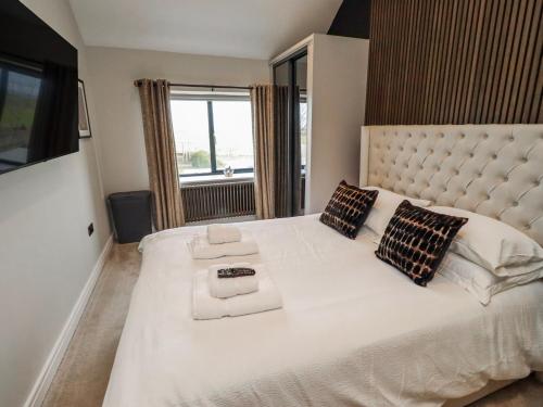 a bedroom with a large white bed with a large window at The Joiners Cottage in Morpeth