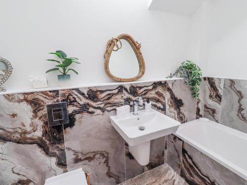 a bathroom with a sink and a mirror at The Joiners Cottage in Morpeth