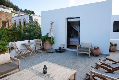 a patio with chairs and a table and a table at Elegant-Lindian Villa Marietta in Lindos