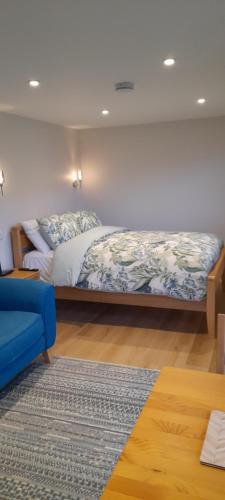 a bedroom with a bed and a blue couch at The Loch Cabin in Fort William