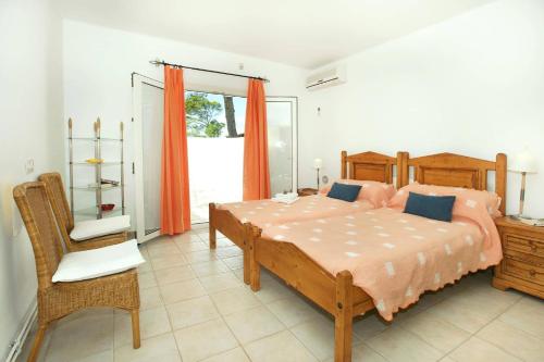 a bedroom with a bed and a chair and a window at Villa Reco by Villa Plus in Felanitx