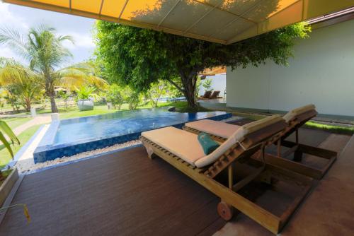 a bed on a patio next to a swimming pool at Uppuveli Beach by DSK in Trincomalee