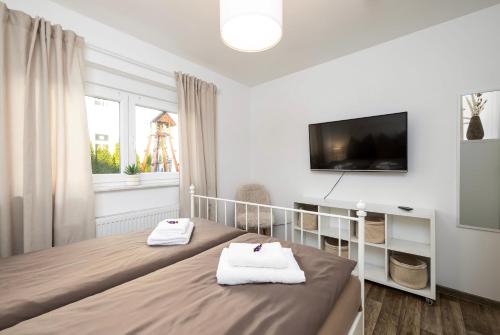 a bedroom with a bed and a tv on the wall at Gemütliches & ruhiges Apartment mit Terrasse, Garten & privatem Stellplatz in Dresden