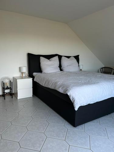 a bedroom with a black bed with white pillows at Oak Wood Ranch Guest Apartment in Marsberg