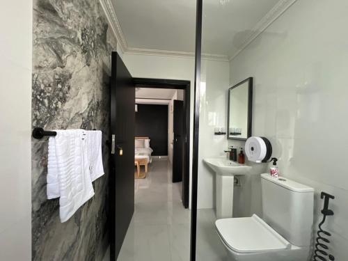 a bathroom with a toilet and a sink at Casa-Pel Villa Grande in Palatswe