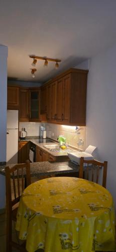 a kitchen with a table with a yellow table cloth on it at Medano House Ocean Beach in El Médano