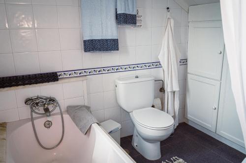 a bathroom with a toilet and a bath tub at Casa dos Avós in Parceiros da Igreja