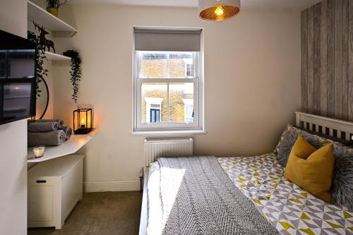 a small bedroom with a bed and a window at Hope Cottage in Hythe