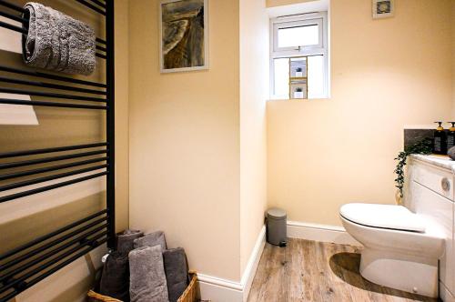 a bathroom with a toilet and a window at Hope Cottage in Hythe