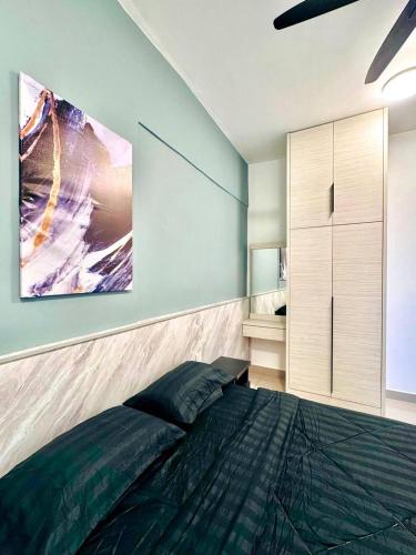 a bedroom with a bed and a painting on the wall at Cloud Nine Homestay in Tanah Rata