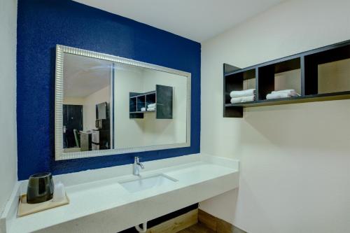 a bathroom with a sink and a mirror at Texas Inn Brownsville by Hotel O in Brownsville