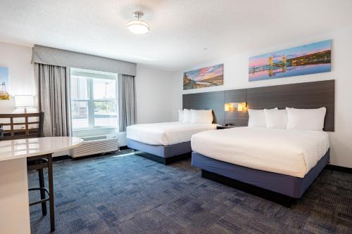 a hotel room with two beds and a desk at Independence Stay Hotel and Long term suites in Houghton