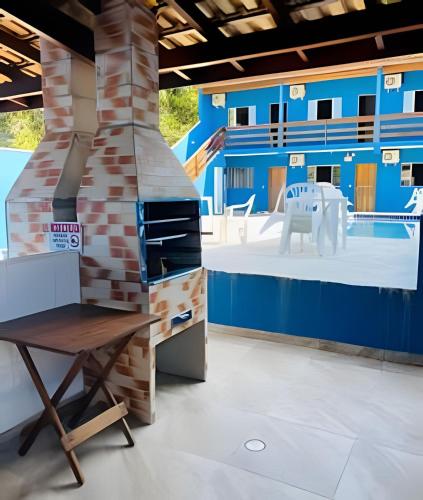 a room with a fireplace and a table and chairs at Chalés do Mako in São Sebastião