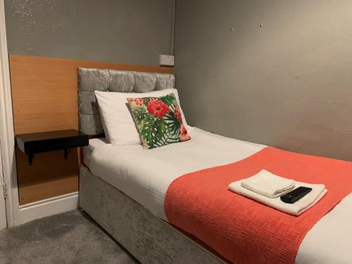 a bedroom with a bed with a red blanket at Coconut Cove in Blackpool