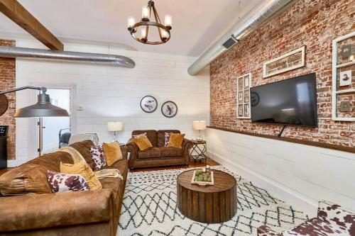 a living room with a brick wall and a tv at Studio 1892 Guesthouse in Hermann
