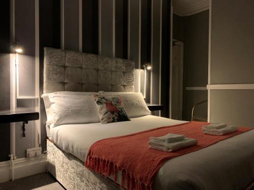 a bedroom with a bed with two towels on it at Coconut Cove in Blackpool