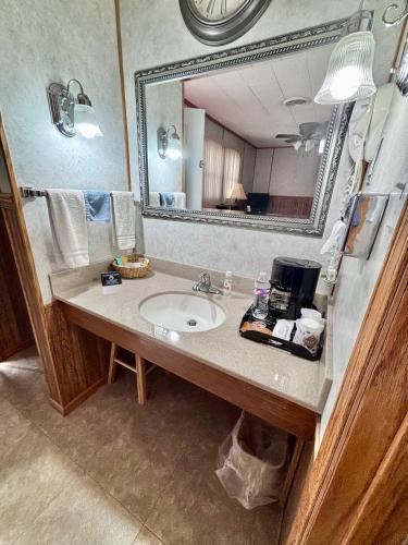 a bathroom with a sink and a large mirror at Starlite Motel in Seneca