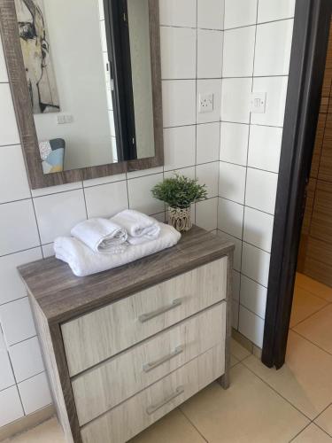 a bathroom with a wooden dresser with towels on it at Seaside Studio in Larnaca