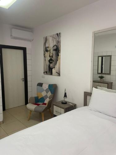 a bedroom with a white bed and a chair at Seaside Studio in Larnaca
