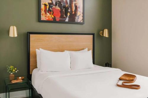 a bedroom with a large white bed with a wooden headboard at LIVN Millennium Park Downtown Chicago Studio in Chicago