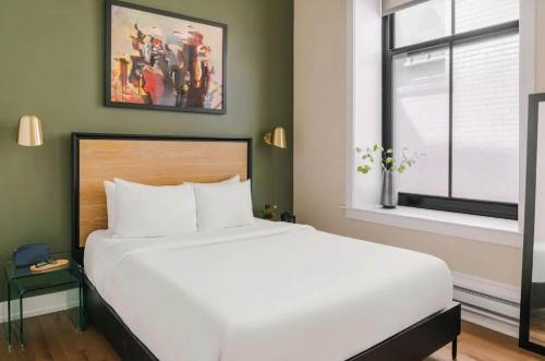 a bedroom with a large white bed and a window at LIVN Millennium Park Downtown Chicago Studio in Chicago