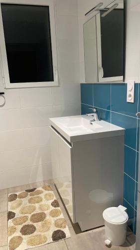 a bathroom with a sink and a toilet and a mirror at Villa turquoise - piscine privée, terrasse bois in Saint-Jean-de-Monts