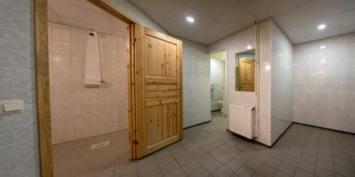 a bathroom with a toilet and a wooden door at Mõedaku Puhkekeskus in Mõedaka