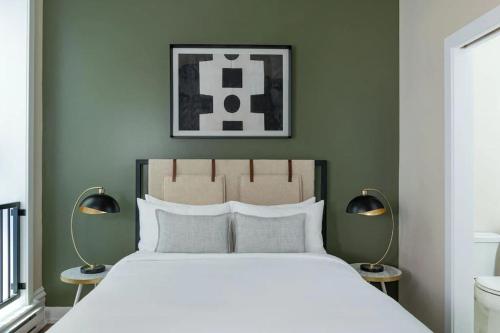 a bedroom with a large white bed with two lamps at LIVN Millennium Park Downtown Chicago 1 BR in Chicago