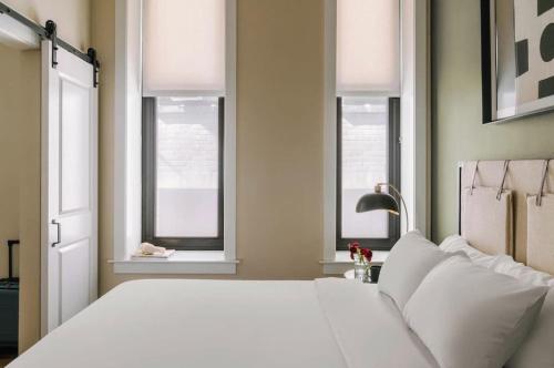 a white bed in a room with windows at LIVN Millennium Park Downtown Chicago 1 BR in Chicago