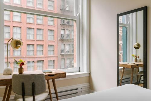 a bedroom with a desk and a large window at LIVN Millennium Park Downtown Chicago Superior 2 BR in Chicago