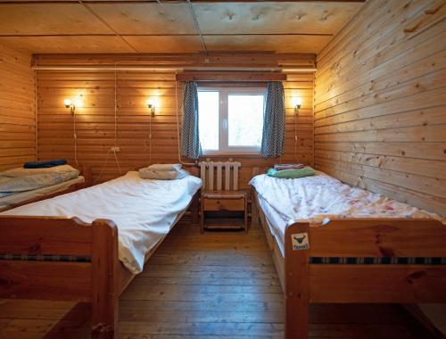a bedroom with two beds in a wooden cabin at Mõedaku Puhkekeskus in Mõedaka