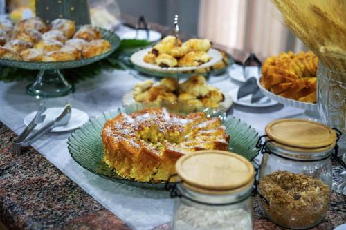 a table topped with plates of pastries and pies at Hotel Dan Inn Express Ribeirão Preto By Nacional Inn in Ribeirão Preto