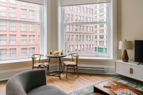 a living room with a table and two large windows at LIVN Millennium Park Downtown Chicago Superior 1BR in Chicago