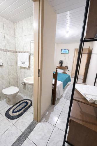 a bathroom with a toilet a sink and a bed at Pertinho do CENTRO - Hospedaria Vila Rica - Excelente Custo Benefício in Ouro Preto