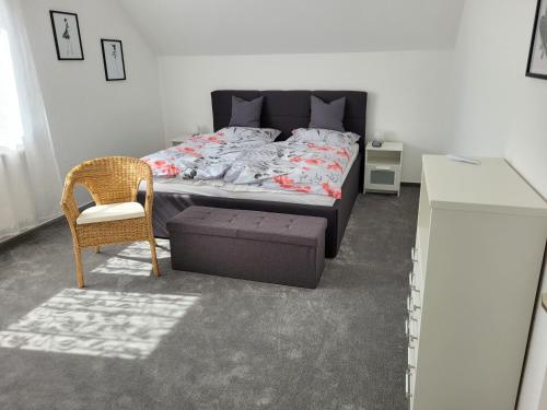 a bedroom with a bed and a chair and a table at Ferienwohnung Bischof in Echzell