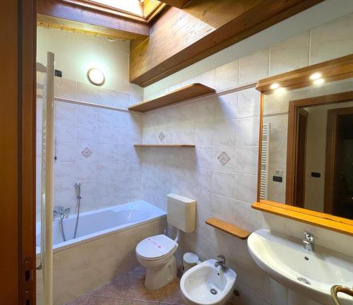 a bathroom with a tub and a toilet and a sink at Alessia in Grado