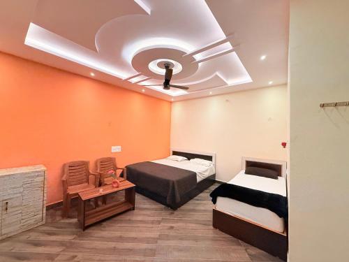 a room with two beds and a ceiling at Italian cafe Hampi in Hampi