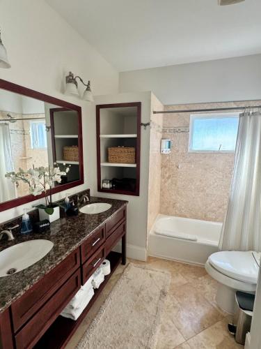 a bathroom with two sinks and a toilet and a tub at Coastal Dunes Escape in Santa Rosa Beach