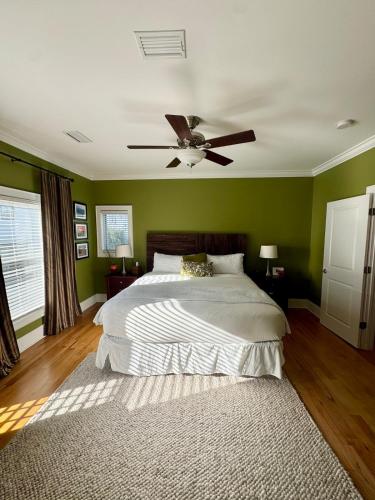 a bedroom with green walls and a bed with a ceiling fan at Coastal Dunes Escape in Santa Rosa Beach