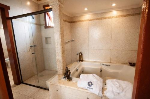 a bathroom with a tub and a shower at Araújo Bazilio Pousada Tiradentes in Tiradentes