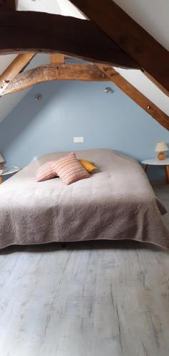a bed with two pillows on it in a attic at La maison de poupées in Bourseul